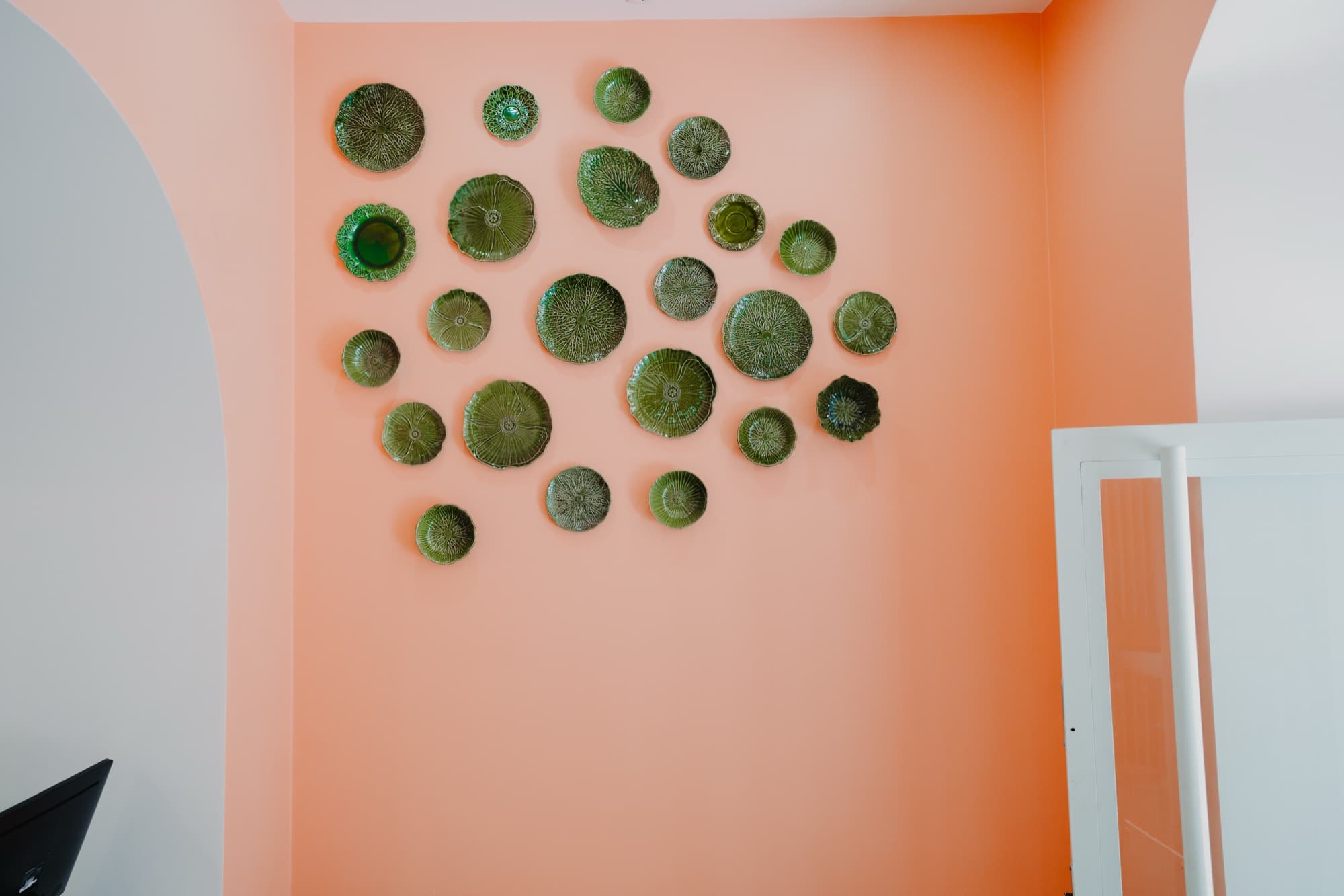 Parede de pratos verdes no Ohana Poke Setúbal